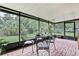 Relaxing screened-in patio with brick flooring, overlooking a serene yard and canal at 17706 Morninghigh Dr, Lutz, FL 33549