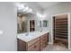 Bathroom with a double vanity, marble countertops and a large walk-in closet at 19974 Bluebird Meadow Dr, Lutz, FL 33558