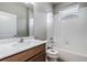 Bright bathroom featuring a shower-tub combo and modern sink with a wood-tone cabinet at 19974 Bluebird Meadow Dr, Lutz, FL 33558