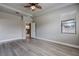 Spacious bedroom includes wood floors, a ceiling fan, and leads to the home's kitchen at 19974 Bluebird Meadow Dr, Lutz, FL 33558