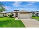 Well-maintained single-story home with lush green lawn, inviting curb appeal, and a two-car garage at 19974 Bluebird Meadow Dr, Lutz, FL 33558