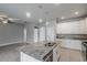 Granite kitchen island with a sink, stainless steel appliances, and white cabinets offering ample storage at 19974 Bluebird Meadow Dr, Lutz, FL 33558