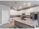 Stylish kitchen featuring white cabinets, granite countertops, a center island and stainless steel appliances at 19974 Bluebird Meadow Dr, Lutz, FL 33558
