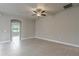 Spacious living room featuring neutral walls, tile flooring, a ceiling fan, and an arched doorway at 19974 Bluebird Meadow Dr, Lutz, FL 33558