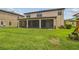 Wide backyard showing lush lawn and a covered patio connected to the main house at 21797 Briske Morning Ave, Land O Lakes, FL 34637