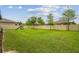 Large backyard with a playset, surrounded by a white fence and lush green grass, perfect for outdoor activities at 21797 Briske Morning Ave, Land O Lakes, FL 34637