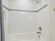 Clean bathtub with white tiled walls and decorative tile accents at 21797 Briske Morning Ave, Land O Lakes, FL 34637