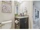 Modern bathroom features granite countertop, dark vanity and a toilet next to a white paneled door at 21797 Briske Morning Ave, Land O Lakes, FL 34637
