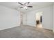 Bright bedroom with ceiling fan, grey carpet, closet doors, and ensuite bathroom at 21797 Briske Morning Ave, Land O Lakes, FL 34637