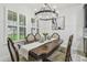 Elegant dining room featuring a wood table, upholstered chairs, and modern chandelier at 21797 Briske Morning Ave, Land O Lakes, FL 34637