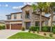 Charming two-story home with a stone facade, covered entry, and vibrant green landscaping with palm trees at 21797 Briske Morning Ave, Land O Lakes, FL 34637