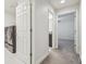 Hallway showing laundry and rooms featuring neutral carpet and white doors at 21797 Briske Morning Ave, Land O Lakes, FL 34637