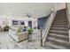 Open concept living space with an adjacent kitchen and staircase with white spindles and a gray carpet at 21797 Briske Morning Ave, Land O Lakes, FL 34637