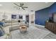 Open living room showcases a comfortable sofa, a modern ceiling fan, and a view of the updated kitchen area at 21797 Briske Morning Ave, Land O Lakes, FL 34637