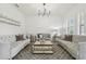 Bright and airy living room featuring elegant sofas, a mirrored coffee table, and neutral decor at 21797 Briske Morning Ave, Land O Lakes, FL 34637