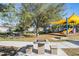 Community playground features a table with chessboard and seating adjacent to playground with slides and covered seating at 21797 Briske Morning Ave, Land O Lakes, FL 34637