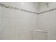 Close up of a shower stall with a built-in seat, decorative tile accents, and shower head at 21797 Briske Morning Ave, Land O Lakes, FL 34637