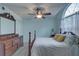 Inviting bedroom with wood-look floors, blue walls, a large arched window, and a decorative wood dresser and bed frame at 2500 Winding Creek Blvd # G307, Clearwater, FL 33761