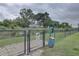 Fenced dog park area with a waste station and signage for responsible pet owners at 2500 Winding Creek Blvd # G307, Clearwater, FL 33761