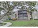 Condo building featuring screened balconies, brick details, and well-maintained landscaping at 2500 Winding Creek Blvd # G307, Clearwater, FL 33761