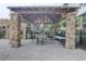 Outdoor patio area featuring stone columns, a grill, seating, and black metal fencing at 2500 Winding Creek Blvd # G307, Clearwater, FL 33761
