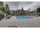Community pool area with ample seating, umbrellas, brick pavers and mature trees at 2500 Winding Creek Blvd # G307, Clearwater, FL 33761