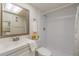 Bright bathroom featuring white subway tile shower and decorative mirror over the sink at 2699 Seville Blvd # 207, Clearwater, FL 33764