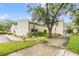 Well-maintained building exterior with manicured landscaping, street lamps, and walkway with gated entrance at 2699 Seville Blvd # 207, Clearwater, FL 33764