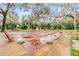 Outdoors lawn bowling area with benches, mature trees, and lush green space creating a relaxing recreation area at 2699 Seville Blvd # 207, Clearwater, FL 33764