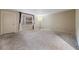 A roomy living area with neutral walls, soft carpet and a window at 2699 Seville Blvd # 207, Clearwater, FL 33764