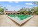 Large rectangular pool surrounded by lounge chairs and lush landscaping on a sunny day at 2699 Seville Blvd # 207, Clearwater, FL 33764