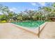 Large community pool and patio surrounded by lush landscaping providing a tranquil escape at 2699 Seville Blvd # 207, Clearwater, FL 33764