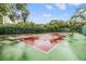 Outdoor tennis court surrounded by lush landscaping, offering a private and scenic sports environment at 2699 Seville Blvd # 207, Clearwater, FL 33764