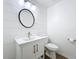 Bathroom featuring a white vanity, modern sink and fixtures, and a stylish round mirror at 27466 Tierra Del Fuego Cir, Punta Gorda, FL 33983
