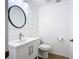 Bathroom featuring a white vanity, modern sink and fixtures, and a stylish round mirror at 27466 Tierra Del Fuego Cir, Punta Gorda, FL 33983