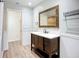 Bathroom with a wood vanity, white countertop, framed mirror and modern light fixture at 27466 Tierra Del Fuego Cir, Punta Gorda, FL 33983