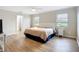 Well-lit bedroom featuring hardwood floors, large windows, and neutral decor at 27466 Tierra Del Fuego Cir, Punta Gorda, FL 33983
