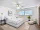 Bright bedroom featuring a ceiling fan, large window, and a seating area with a chair and ottoman at 27466 Tierra Del Fuego Cir, Punta Gorda, FL 33983