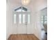 Bright foyer featuring a decorative glass front door, modern light fixture, and wood-look flooring at 27466 Tierra Del Fuego Cir, Punta Gorda, FL 33983