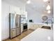 Bright, modern kitchen featuring stainless steel appliances, white cabinets, an island, and hardwood floors at 27466 Tierra Del Fuego Cir, Punta Gorda, FL 33983