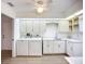 Bright laundry room with white cabinets, sink, and washer/dryer combo at 27466 Tierra Del Fuego Cir, Punta Gorda, FL 33983