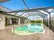 Inviting in-ground pool within a screened enclosure with lush landscaping, seamlessly connected to the home's lanai at 27466 Tierra Del Fuego Cir, Punta Gorda, FL 33983