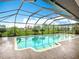The screened-in pool features a tile trim and lush landscaping, perfect for staying cool on hot days at 27466 Tierra Del Fuego Cir, Punta Gorda, FL 33983