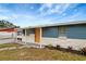 Lovely home featuring blue exterior, white stone accents, landscaping, and a bright yellow front door at 3204 Dodge St, Tampa, FL 33605