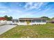 Charming single-story home featuring blue exterior, white stone accents, and a bright yellow front door at 3204 Dodge St, Tampa, FL 33605