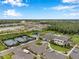 Aerial view of a community with tennis courts, pool, clubhouse, parking and landscaping at 32490 Tree Of Life Ave, Wesley Chapel, FL 33543