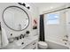 Well-lit bathroom features marble countertop, black accents, and shower-tub combo at 32490 Tree Of Life Ave, Wesley Chapel, FL 33543