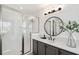 Bright bathroom featuring a walk-in shower, gray cabinets, sleek black fixtures, and tile floors at 32490 Tree Of Life Ave, Wesley Chapel, FL 33543
