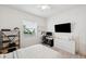 Well-lit bedroom with desk, mounted TV, shelving, and modern minimalist style at 32490 Tree Of Life Ave, Wesley Chapel, FL 33543