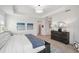 Bright bedroom with light wood floors, a blue accent rug and bench at the foot of the bed at 32490 Tree Of Life Ave, Wesley Chapel, FL 33543